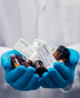 Medical professional holding two handfulls of prescription medication