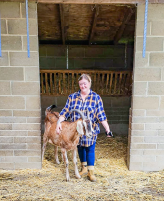 Image of Louise Bloom, Credit Controller, at PACT animal sanctuary with a large goat