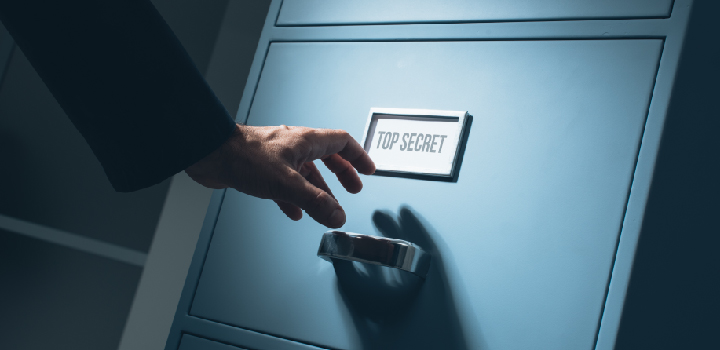 Stock photo of hand reading into drawer labelled Top Secret